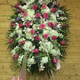 Large standing floral spray with pink roses and white blooms on a ribbon stand