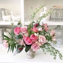 Pink roses and alstroemeria arranged in a speckled vase