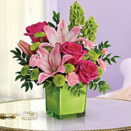 Pink lilies and roses in a green square vase