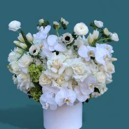 White floral arrangement in a white cylindrical vase