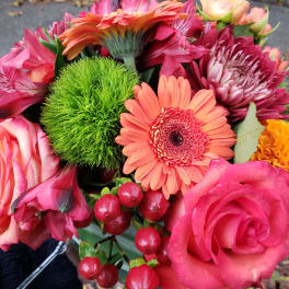 Bright bouquet with pink roses, orange gerbera daisy, green dianthus ball, red berries, and mums