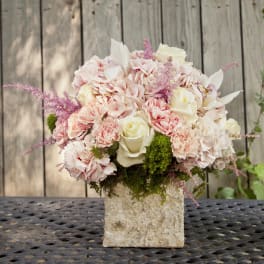Blush and white floral arrangement in a textured square vase