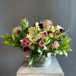Mixed bouquet in a ribbed metal vase with burgundy and pale pink blooms