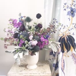 Purple and white mixed bouquet in a white vase