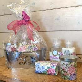 Gift basket with floral bath products and a pink ribbon butterfly topper