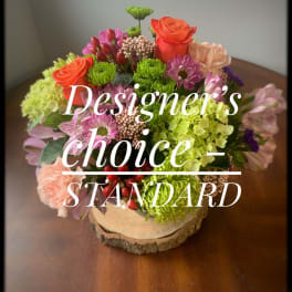 Mixed bouquet with roses, chrysanthemums, and hydrangeas on a wood slice base
