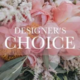 Pink floral arrangement with large blooms and greenery, overlaid with text reading "DESIGNER'S CHOICE"