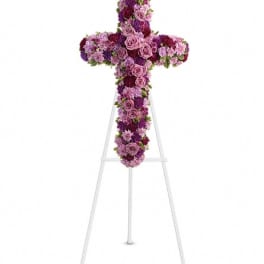 Purple and pink floral cross on a white stand