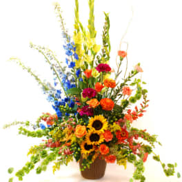 Tall mixed flower arrangement in a brown vase with sunflowers and bright blooms