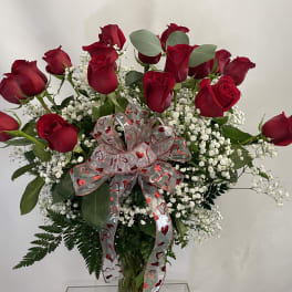 Bouquet of red roses with baby's breath and a heart-patterned ribbon