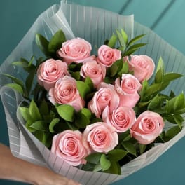 Bouquet of pink roses wrapped in striped paper