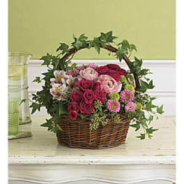 Basket of pink and red roses with daisies and greenery