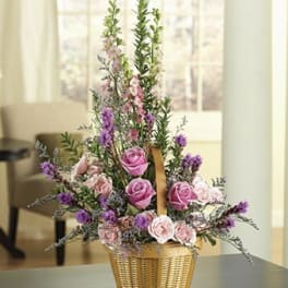 Pink roses and purple flowers in a woven basket