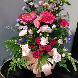 Pink and purple mixed flower arrangement with a satin bow