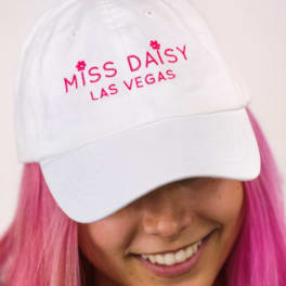 White cap with pink "Miss Daisy Las Vegas" embroidery