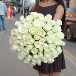 Woman holding a large bouquet of white roses