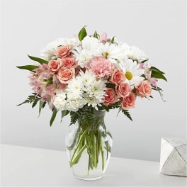 Pink roses and white daisies in a clear glass vase