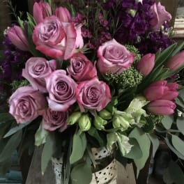 Pink and lavender roses with tulips in a spotted vase