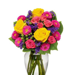 Mixed bouquet of yellow and pink roses in a clear glass vase