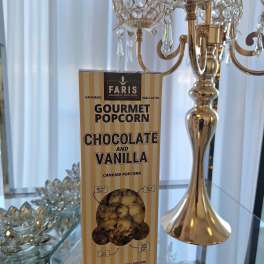 Box of chocolate and vanilla gourmet popcorn on a mirrored table