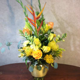 Tall mixed bouquet in a glass vase with orange and yellow flowers