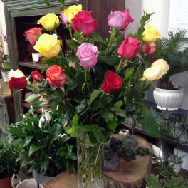 Mixed roses in a clear glass vase with white blooms at the base