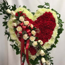 Heart-shaped floral spray with red and white flowers and cream roses