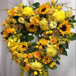 Heart-shaped yellow floral standing spray with sunflowers and roses