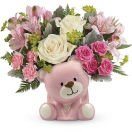 Pink teddy bear vase filled with pink and white flowers