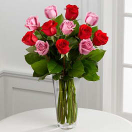 Bouquet of red and pink roses in a clear glass vase