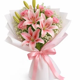 Pink lilies and roses in white wrapping with a pink ribbon