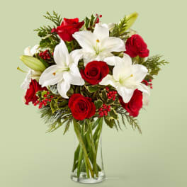 Red roses and white lilies in a clear glass vase
