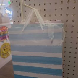 Striped blue-and-white gift bag hanging on a pegboard display