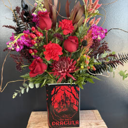 Red and purple floral arrangement in a Dracula-themed vase