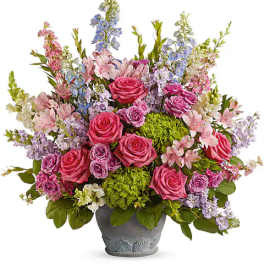 Mixed pink and lavender flowers arranged in a gray pot