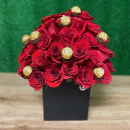 Dome of red roses with gold-wrapped chocolates arranged in a black square box