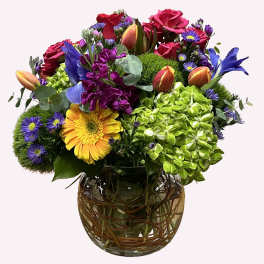 Mixed bouquet of roses, hydrangea, and daisies in a glass vase
