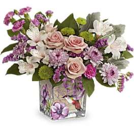 Pink and white floral arrangement in a decorated glass vase