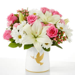 Pink roses and white lilies in a white vase with a gold dove design