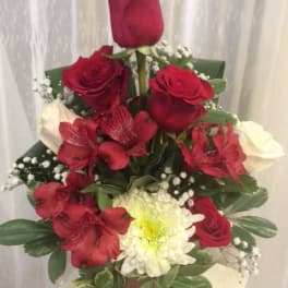 Red roses and white flowers arranged in a vase