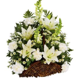 White lilies and small white flowers in a wicker basket