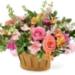Mixed pink and orange flowers in a wooden basket