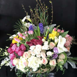 Large mixed bouquet with pink, white, yellow, and purple flowers in a vase