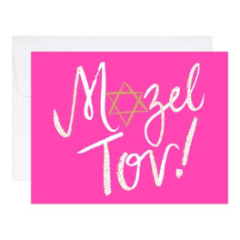 Pink greeting card with white and gold lettering in front of a white envelope