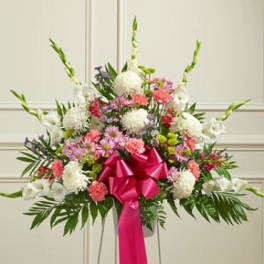 Standing floral spray with pink and white flowers and a bright pink bow