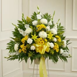Standing floral spray with white and yellow flowers on a metal easel