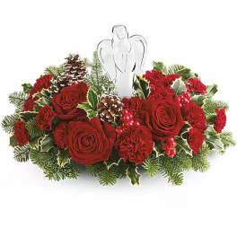 Red roses and carnations arranged with pinecones and an angel topper