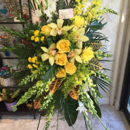 Tall yellow floral standing spray with roses and orchids