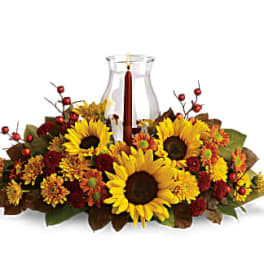 Sunflower centerpiece around a glass hurricane candle holder