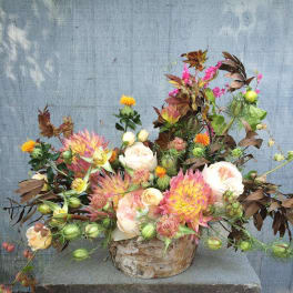 Mixed bouquet of pink and white flowers in a birch bark container